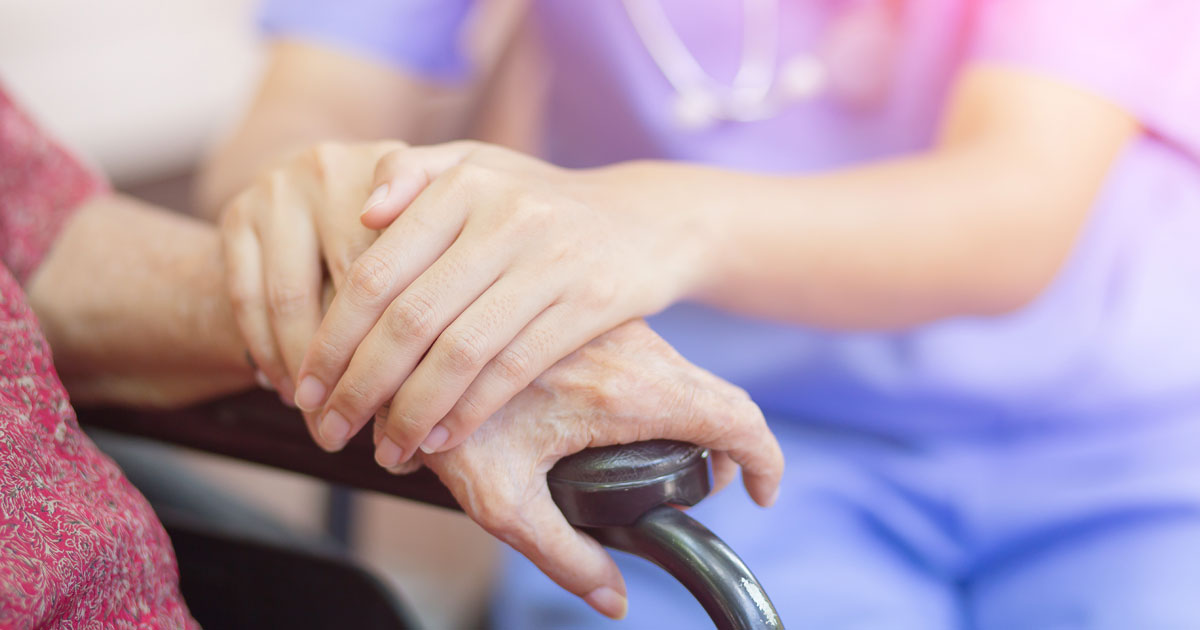 Caretaker and Elderly Woman Holding Hands